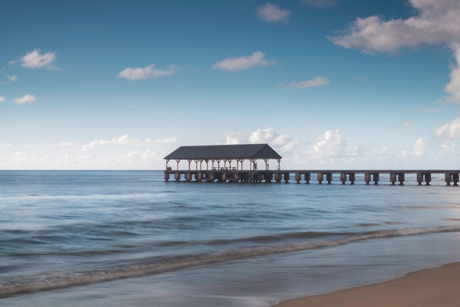 Covered pier pavilion on calm blue ocean